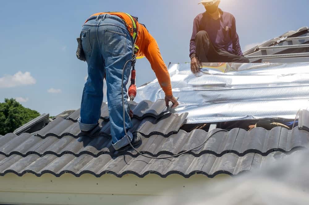 Roof Repair Worker Replacing Gray Tiles Or Shingles On House Roof Replacement Nassau County, NY
